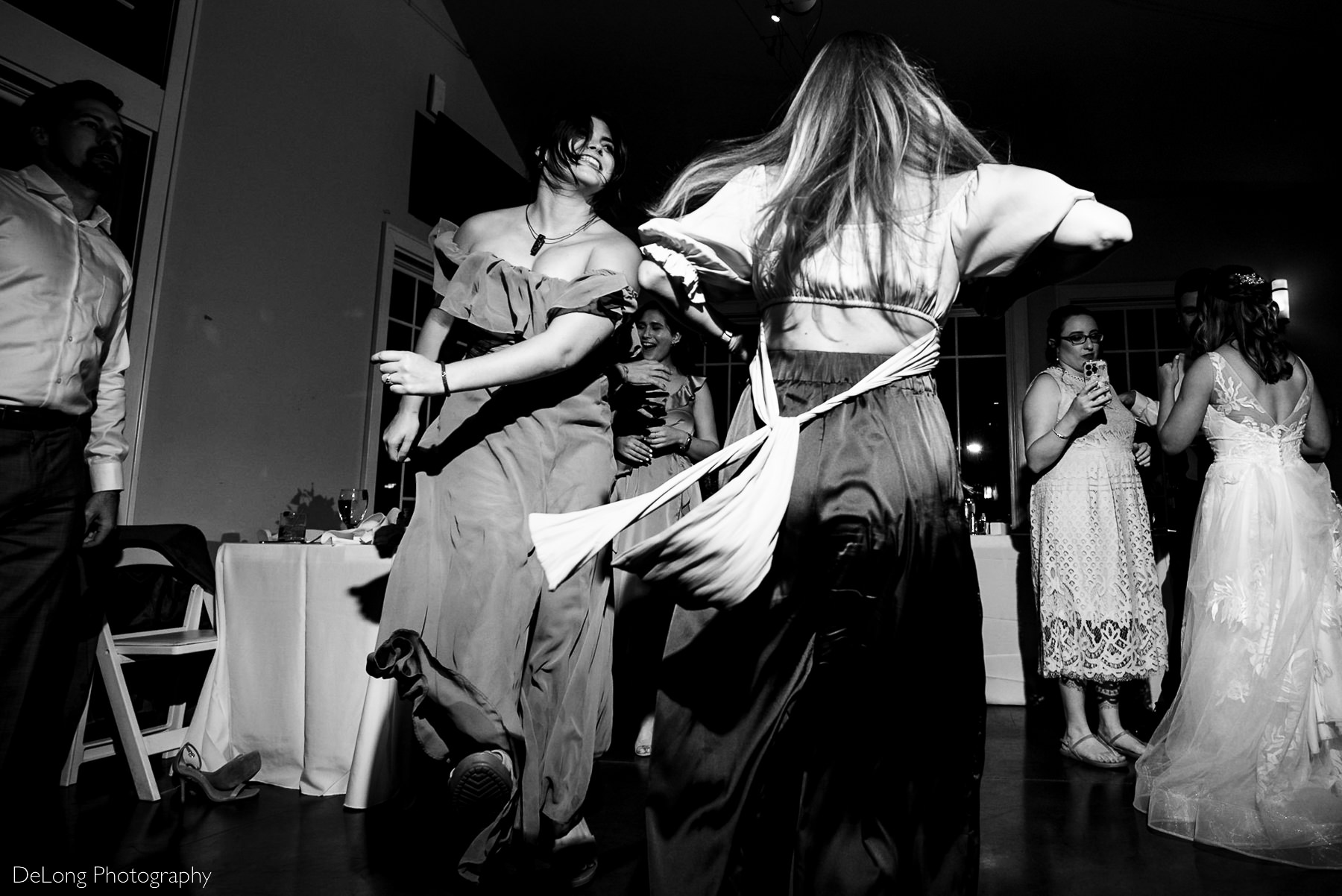 Black and white image showing motion of wedding guests dancing in Charlotte, NC by Charlotte wedding Photographers DeLong Photography