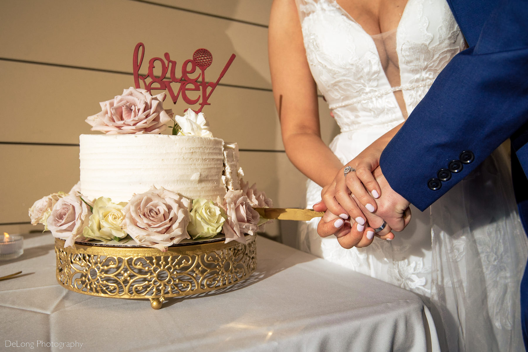 Up close image of bride and groom's hands on their cake knife as their cutting their cake at Pine Island Country Club in Charlotte, NC by Charlotte wedding Photographers DeLong Photography