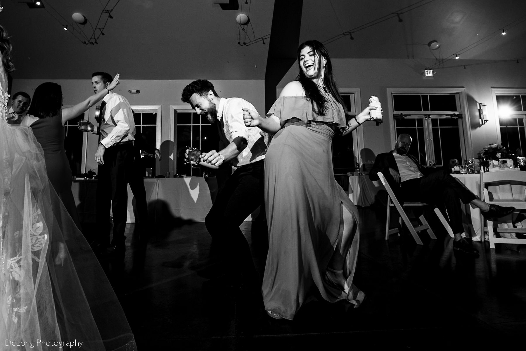 Black and white image of guests singing, laughing and dancing on the dance floor at Pine Island Country Club in Charlotte, NC by Charlotte wedding Photographers DeLong Photography