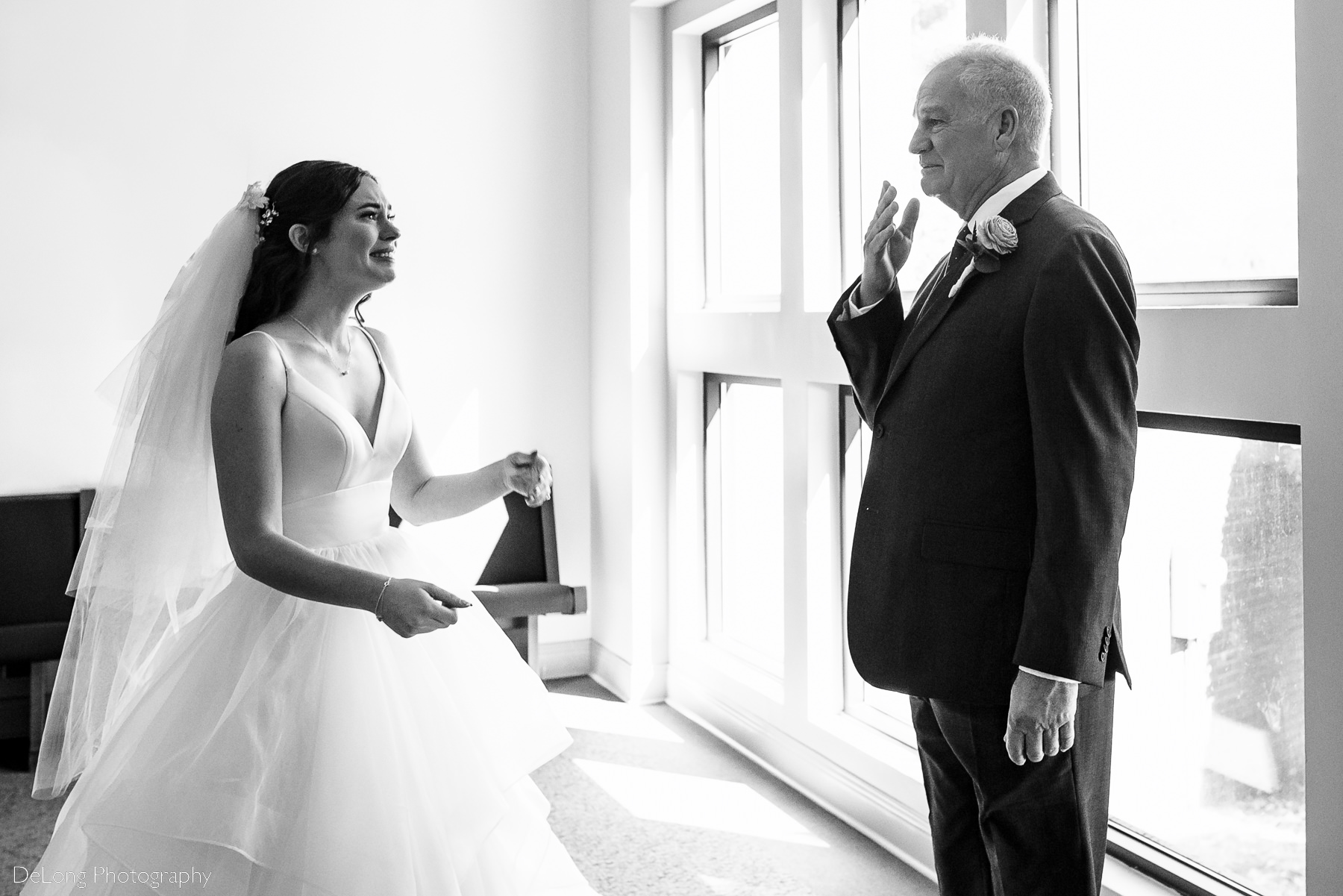 Emotional father and daughter during their first look at St Gabriel Catholic Church in Charlotte, NC by Charlotte wedding photographers DeLong Photography