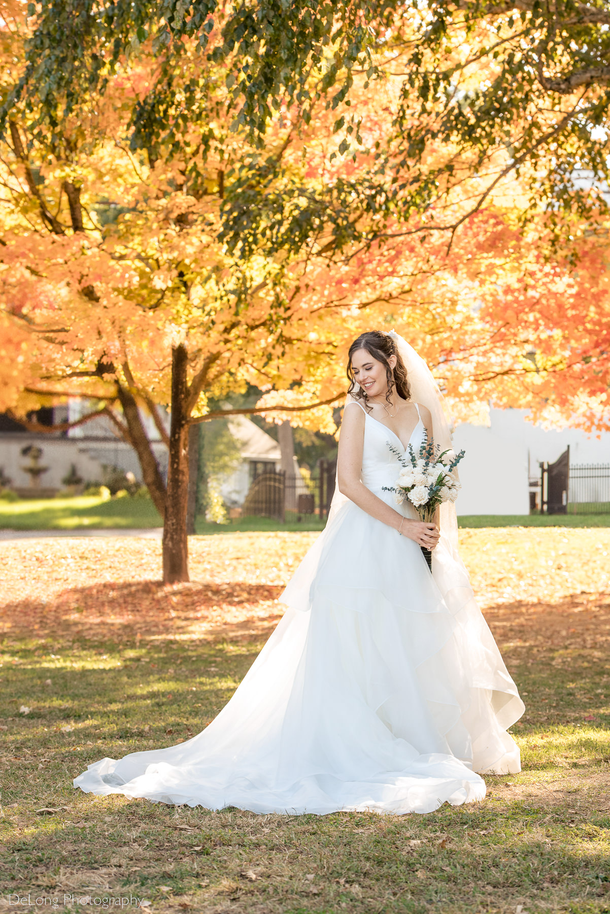 Bridal portrait in front of orange and yellow fall trees at Freedom Park by Charlotte wedding photographers DeLong Photography