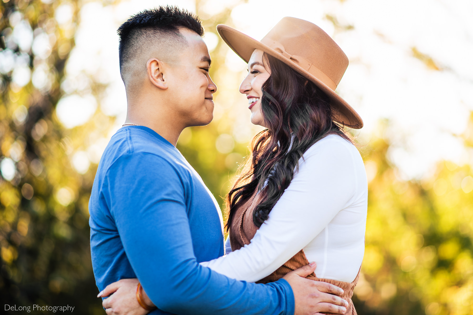 Couple gigging with arms around each other following surprise proposal at Riverfront Park in Columbia, SC. Photo by Charlotte wedding photographers DeLong Photography.