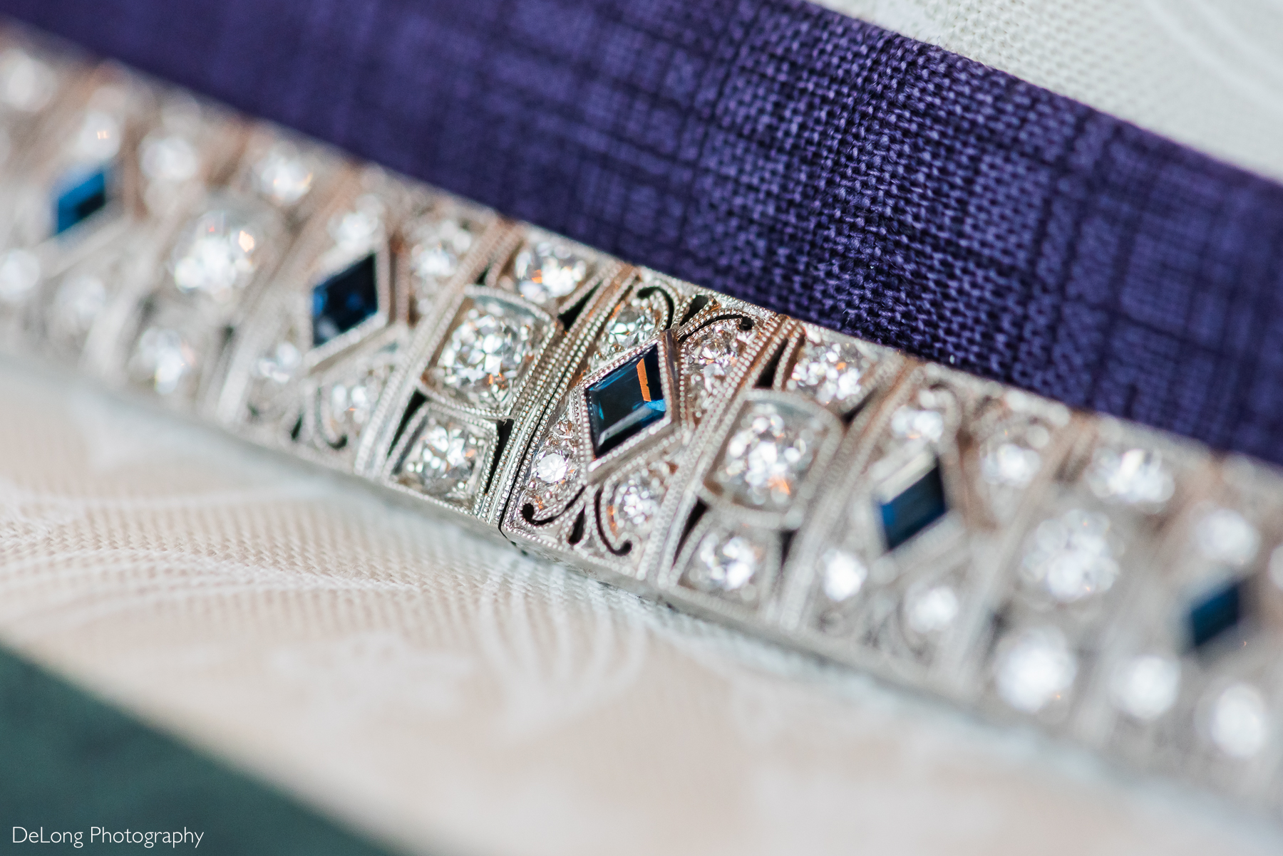 Macro detail photograph focused on the sapphire and diamond pattern of the art deco bracelet heirloom the bride wore on her wedding day. Photograph by Charlotte wedding photographers DeLong Photography taken in the Kimpton Hotel Arras.