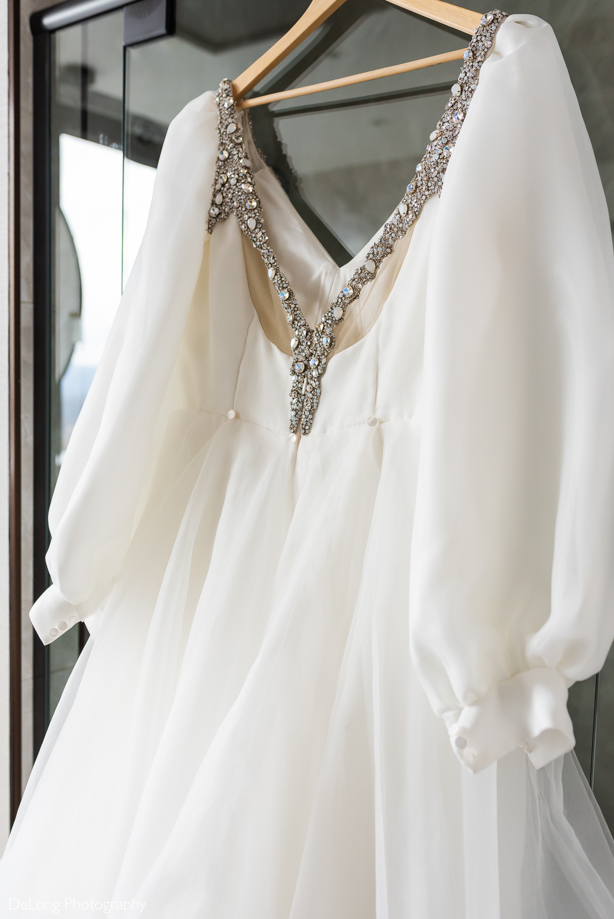 Back of bride's dress showcasing the bejeweled straps. Photograph by Charlotte wedding photographers DeLong Photography taken in the Kimpton Hotel Arras.