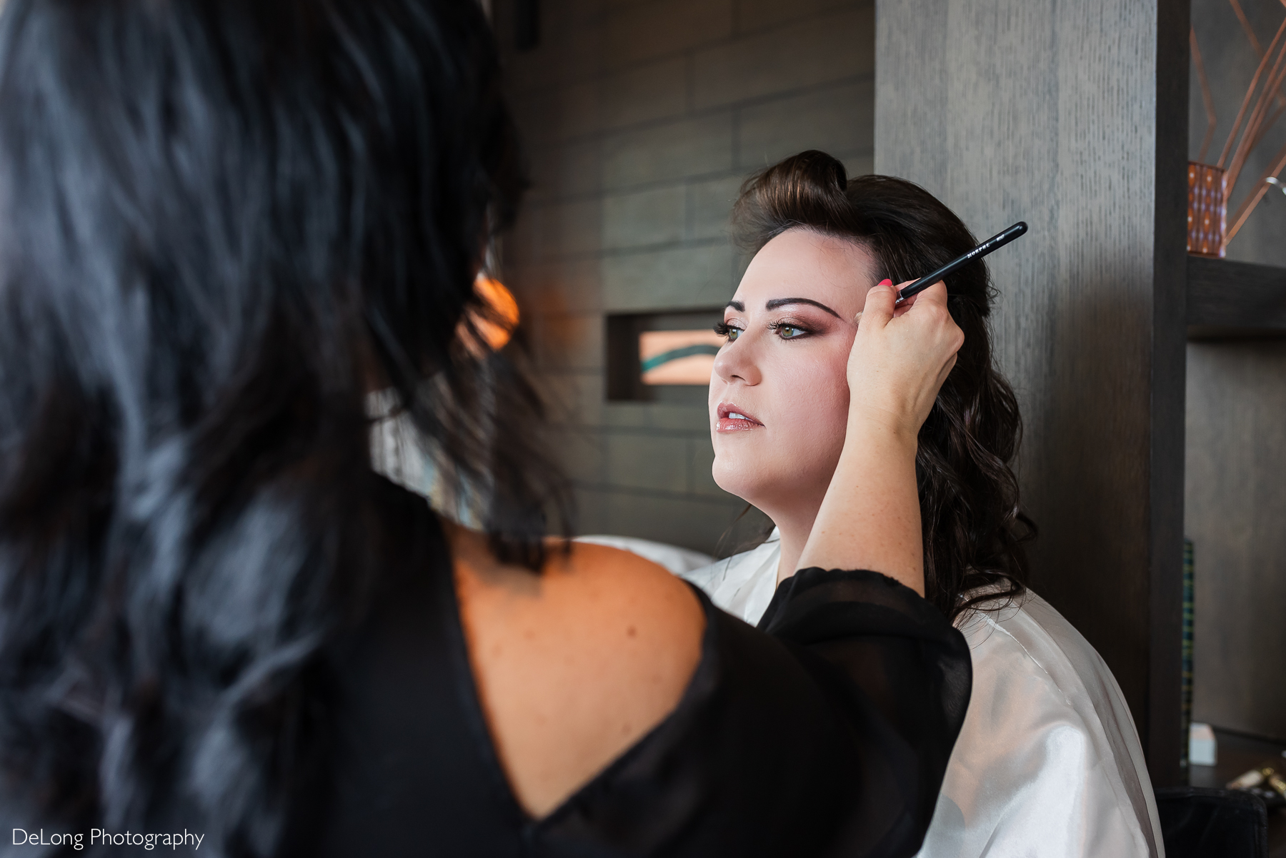 Bride having her eye makeup done by Updos Studios. Photograph by Charlotte wedding photographers DeLong Photography taken in the Kimpton Hotel Arras.