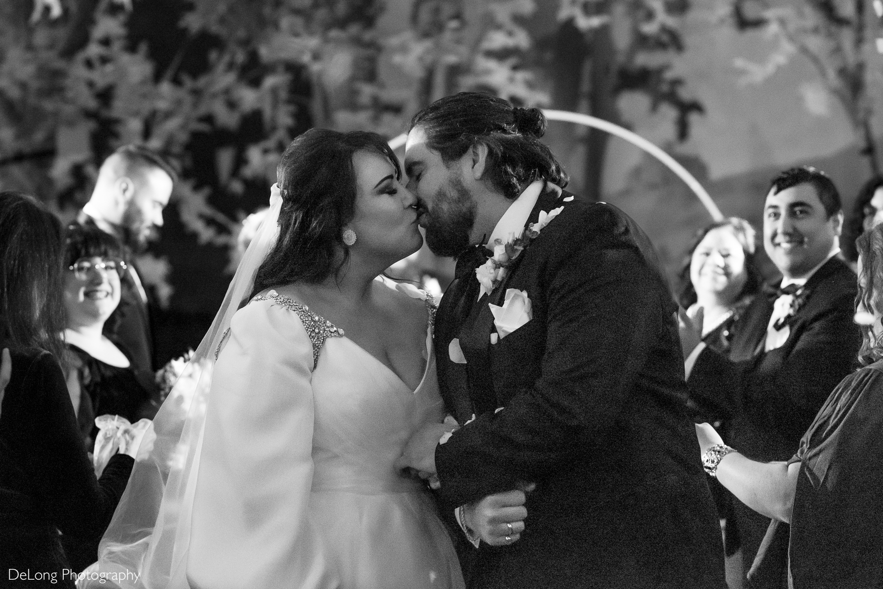 Bride and groom sharing a kiss as they recess down the aisle post-ceremony. Photograph by Charlotte wedding photographers DeLong Photography taken at the Asheville Masonic Temple.