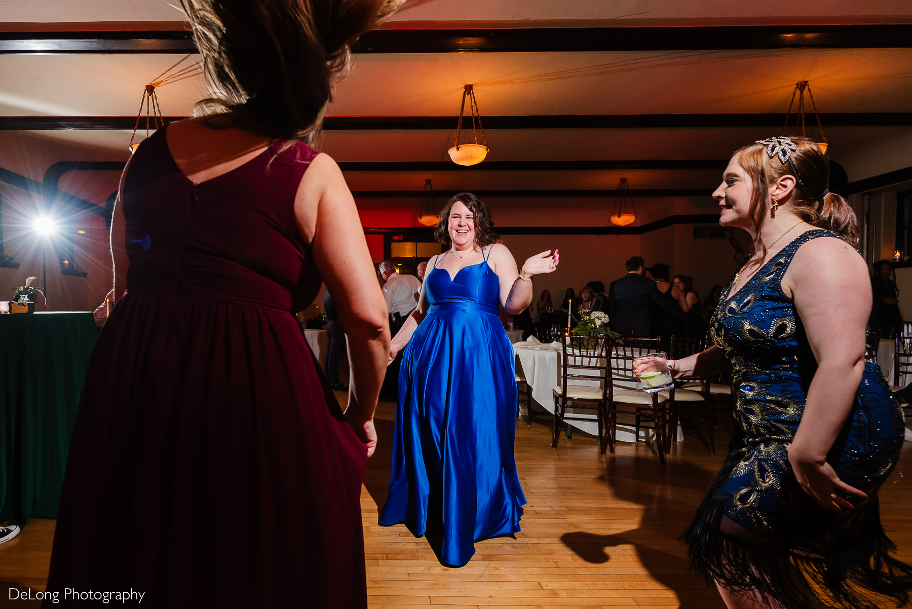 Candid photograph of guests smiling and enjoying the dance floor. Photograph by Charlotte wedding photographers DeLong Photography taken at the Asheville Masonic Temple.