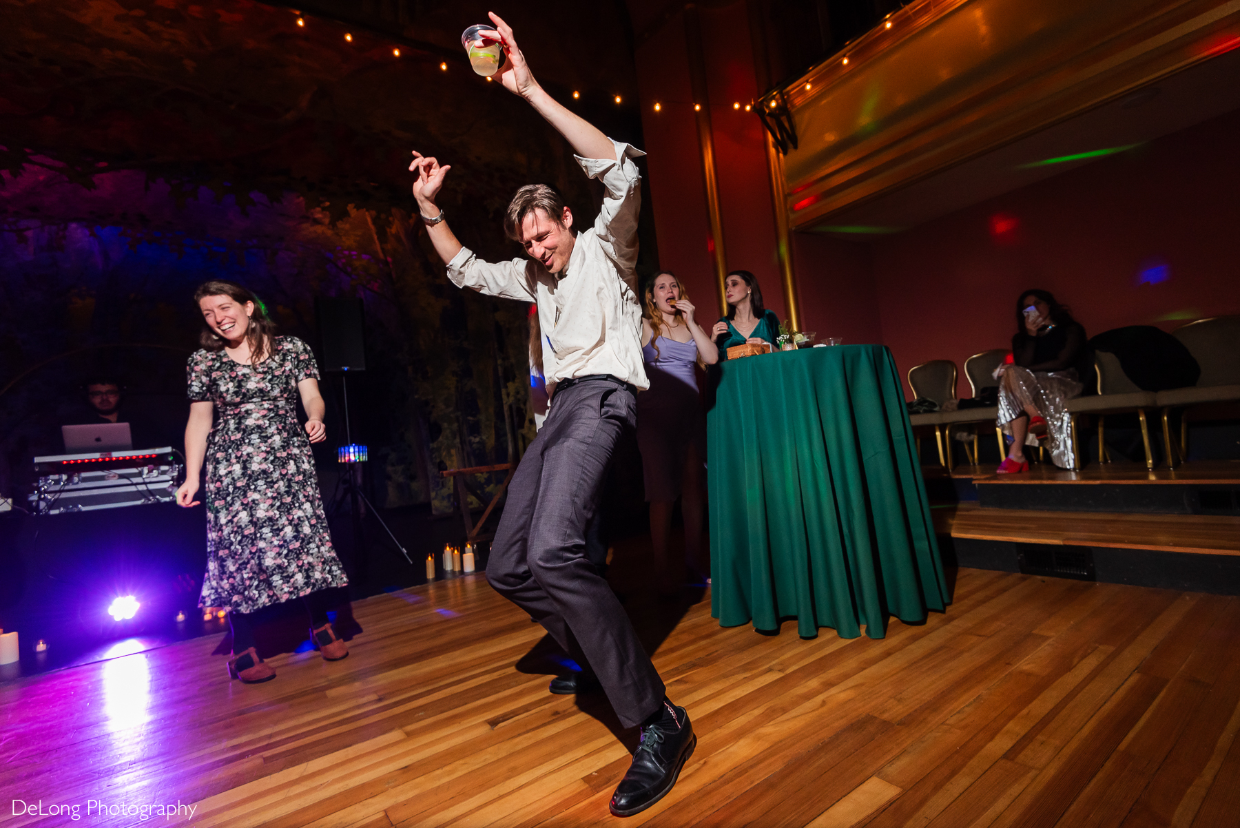 Candid, up close photo of a male guest dancing with his hands in the air. Photograph by Charlotte wedding photographers DeLong Photography taken at the Asheville Masonic Temple.