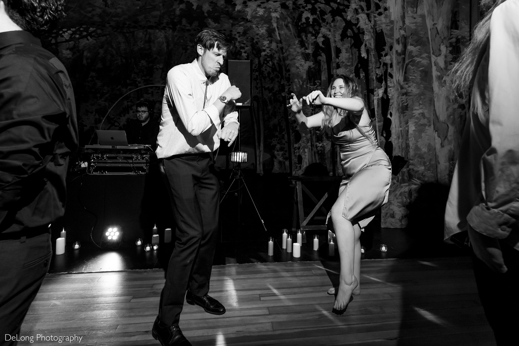 Two guests laughing and making silly faces while dancing. Photograph by Charlotte wedding photographers DeLong Photography taken at the Asheville Masonic Temple.