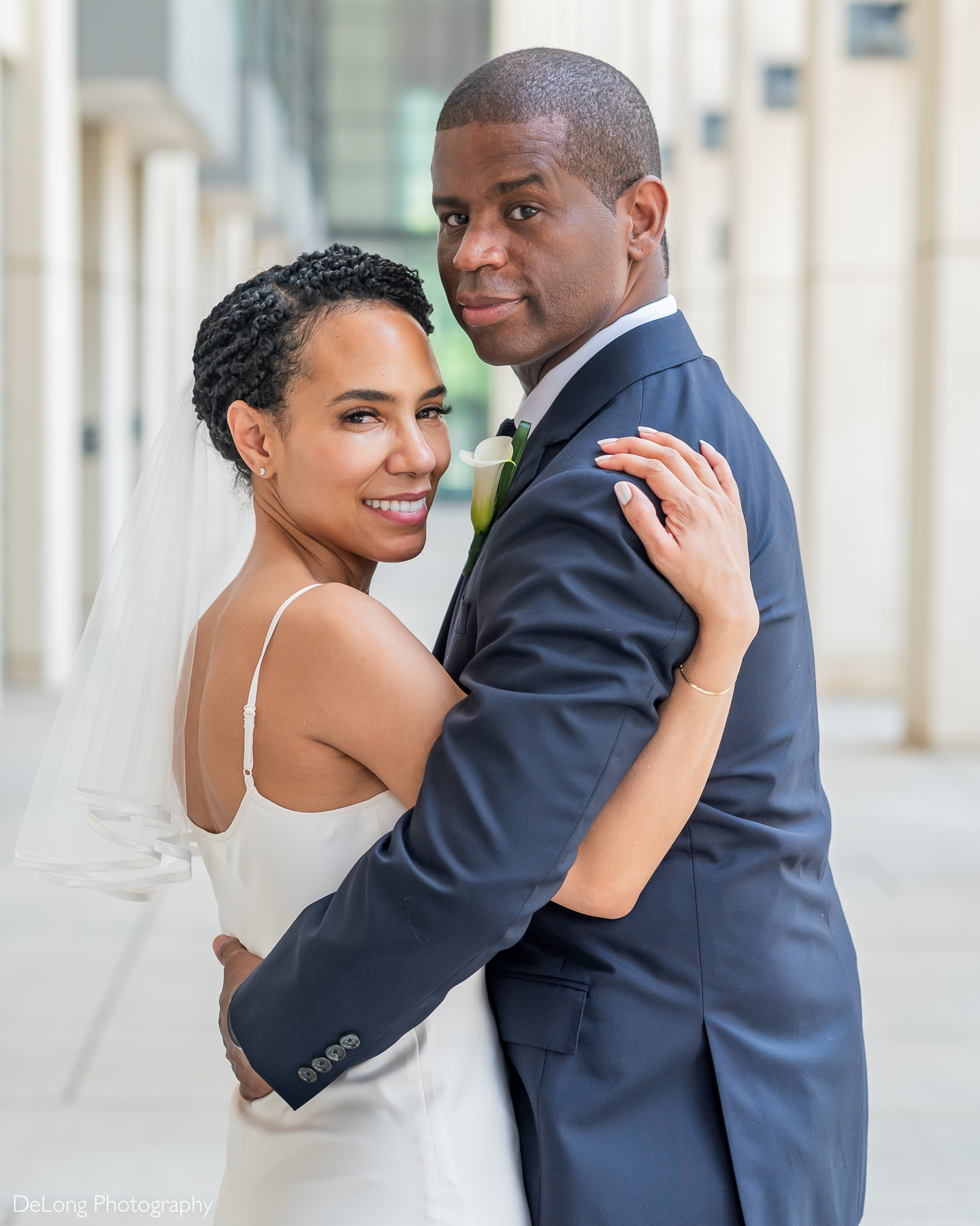 A joyful bride and groom embrace during their Uptown Charlotte wedding, captured in a romantic editorial-style portrait by DeLong Photography. Known for modern, luxury wedding photography in Charlotte, NC, DeLong Photography specializes in timeless imagery for stylish couples.