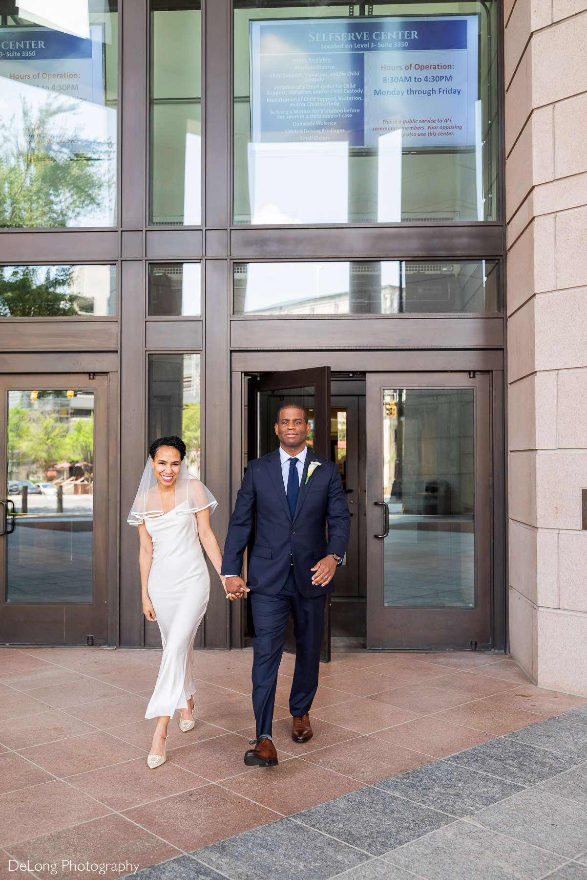 Elegant Charlotte courthouse elopement at Mecklenburg County Courthouse captured by luxury wedding photographer DeLong Photography. The stylish bride and groom walk hand-in-hand just married, perfect inspiration for engaged couples planning an intimate Uptown Charlotte elopement.