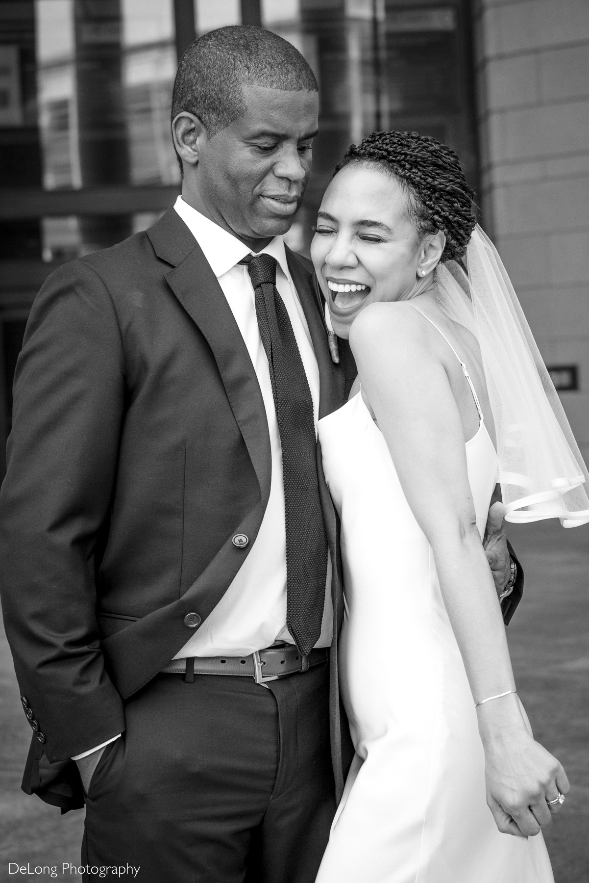 Joyful bride and groom sharing a candid, playful moment during their luxury courthouse elopement at Mecklenburg County Courthouse, captured by Charlotte elopement photographer specializing in intimate and stylish weddings.