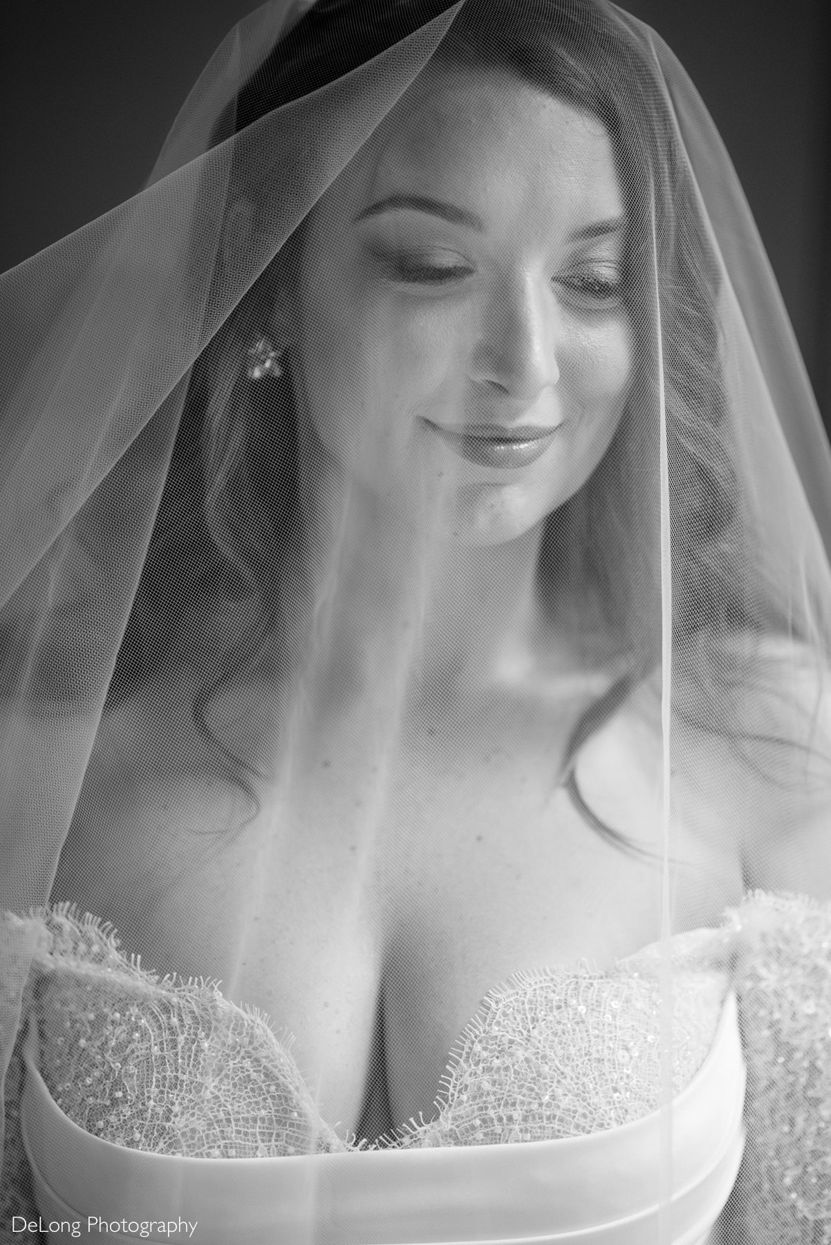 Close-up black and white bridal portrait at The White Home in Rock Hill, SC, featuring a bride in a beaded lace gown with a soft tulle veil gently framing her face, captured by DeLong Photography.