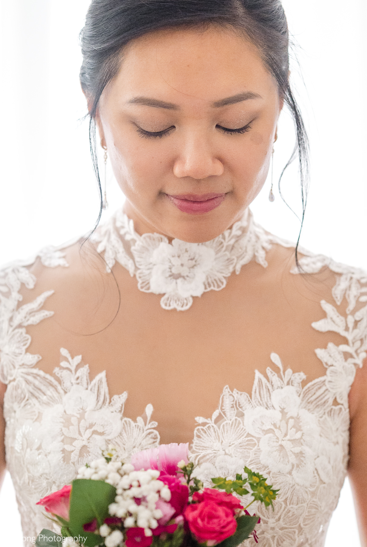 Bride wearing a modern Áo Dài-inspired lace jumpsuit and holding a bright pink bouquet before her fall Raleigh elopement, photographed by DeLong Photography.