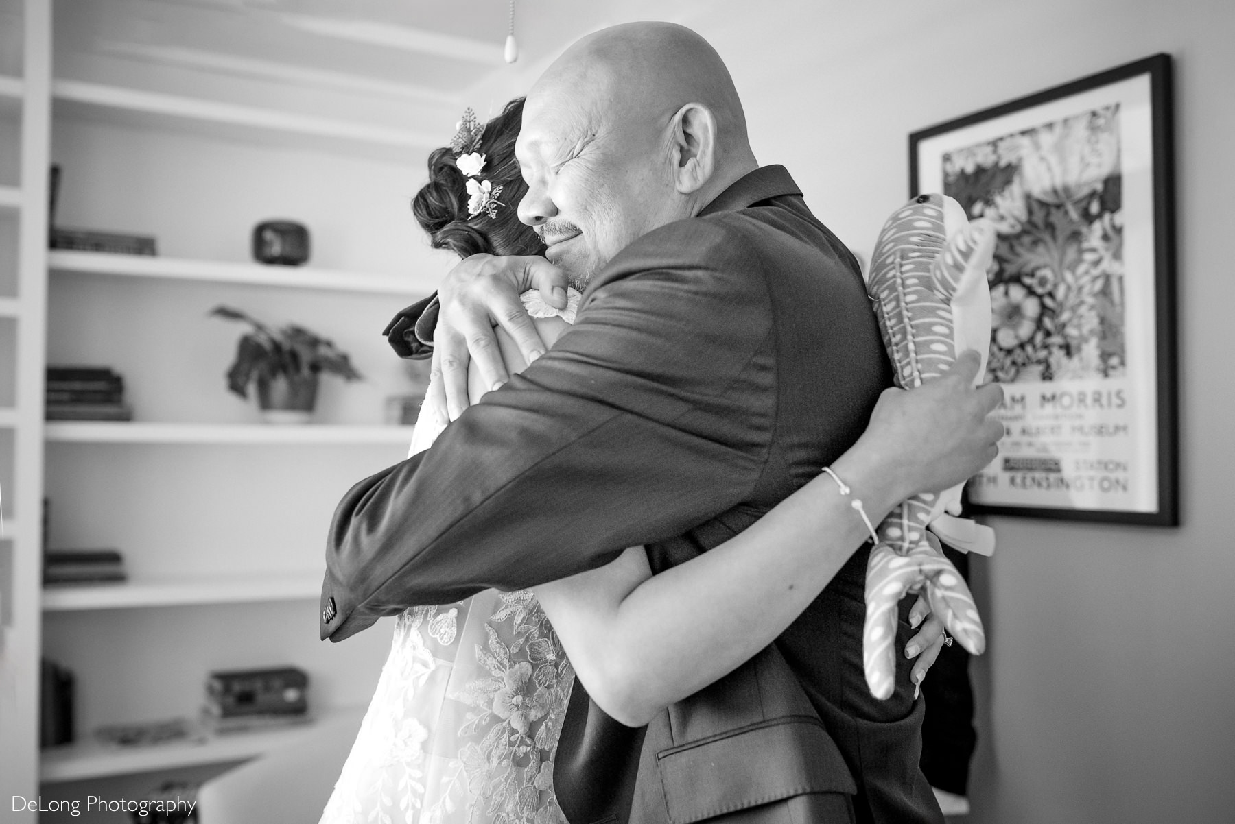 Emotional father-daughter hug before a fall Raleigh elopement at Wake County Courthouse, captured by DeLong Photography. The bride wears a lace Áo Dài-inspired jumpsuit to honor her Vietnamese heritage.
