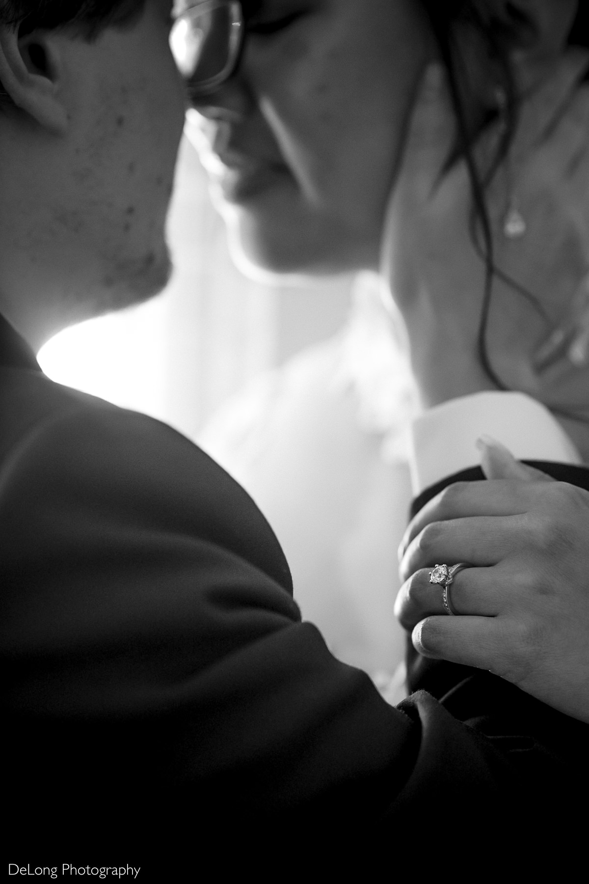 Close-up of newlyweds sharing an intimate moment during their Raleigh elopement, highlighting the bride’s engagement ring and emotional connection, photographed by DeLong Photography.