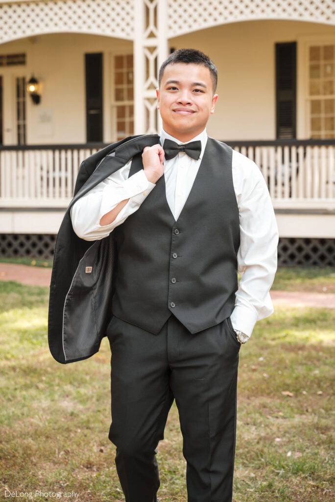 Groom in black tuxedo posing confidently outside The White Home in Rock Hill, SC, captured by a professional wedding photographer specializing in timeless wedding portraits.
