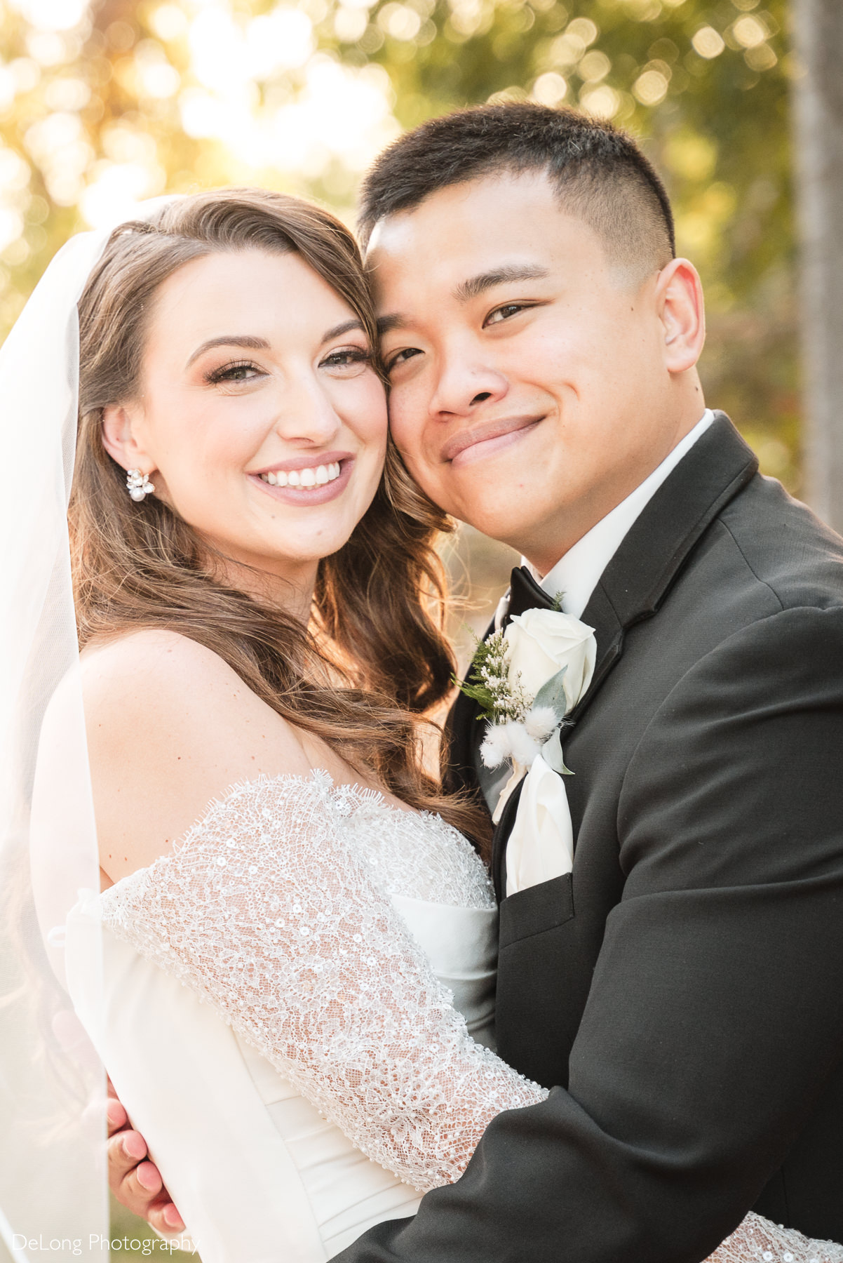 Bride and groom smiling and embracing during golden hour portraits at The White Home in Rock Hill, photographed by DeLong Photography.