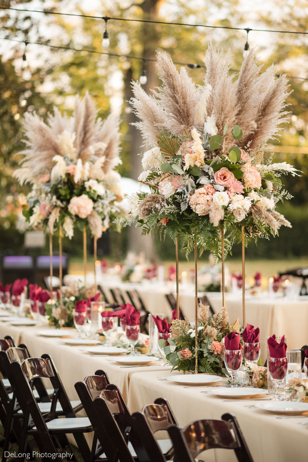 Peach, burgundy, cream, nude, orange, and green floral centerpieces at a boho-glam wedding reception at The White Home in Rock Hill, SC.