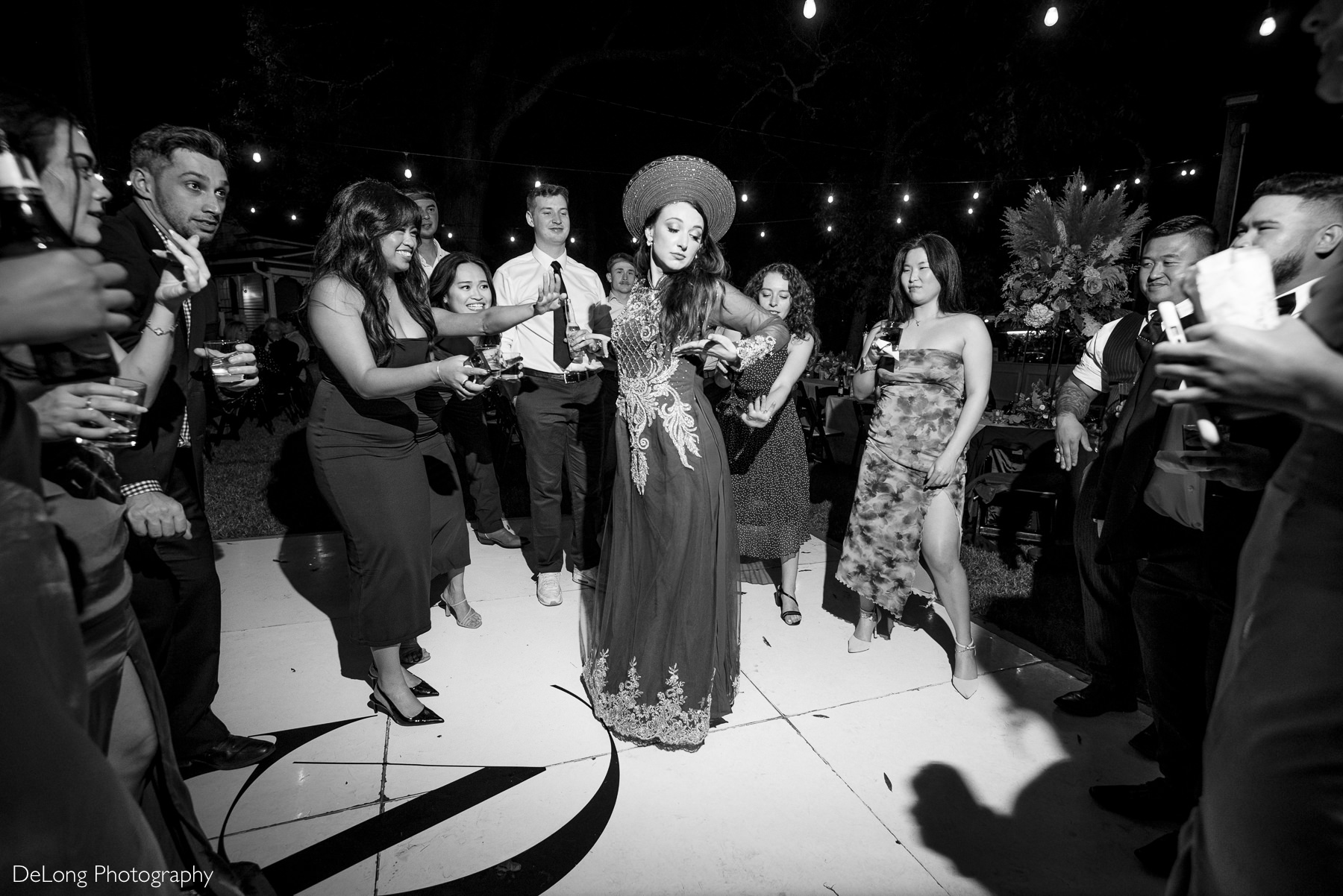 Cultural wedding attire meets modern celebration as bride in áo dài is cheered on by friends during Rock Hill wedding reception.