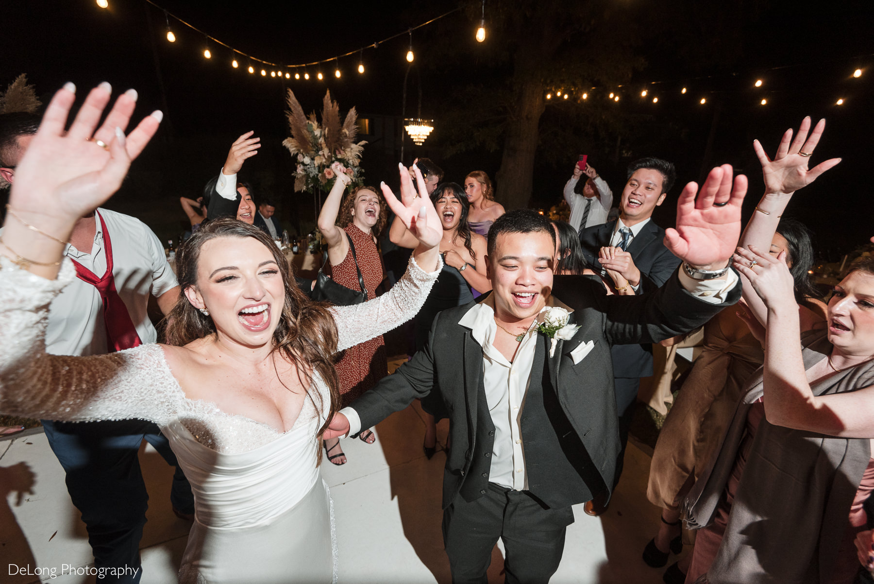 Newlyweds surrounded by cheering guests during high-energy reception at The White Home in Rock Hill.