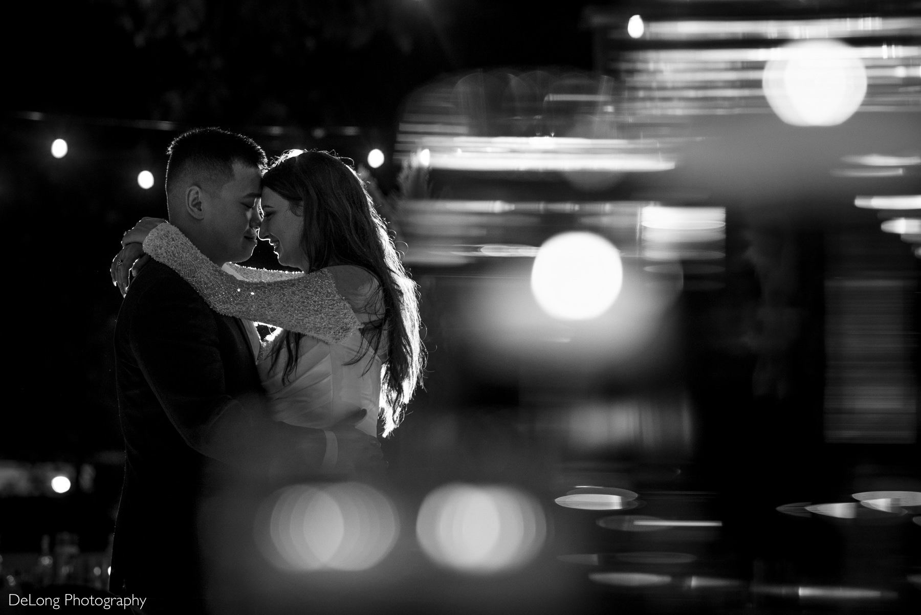 Newlyweds enjoy an intimate moment together at night surrounded by glowing lights at The White Home wedding.