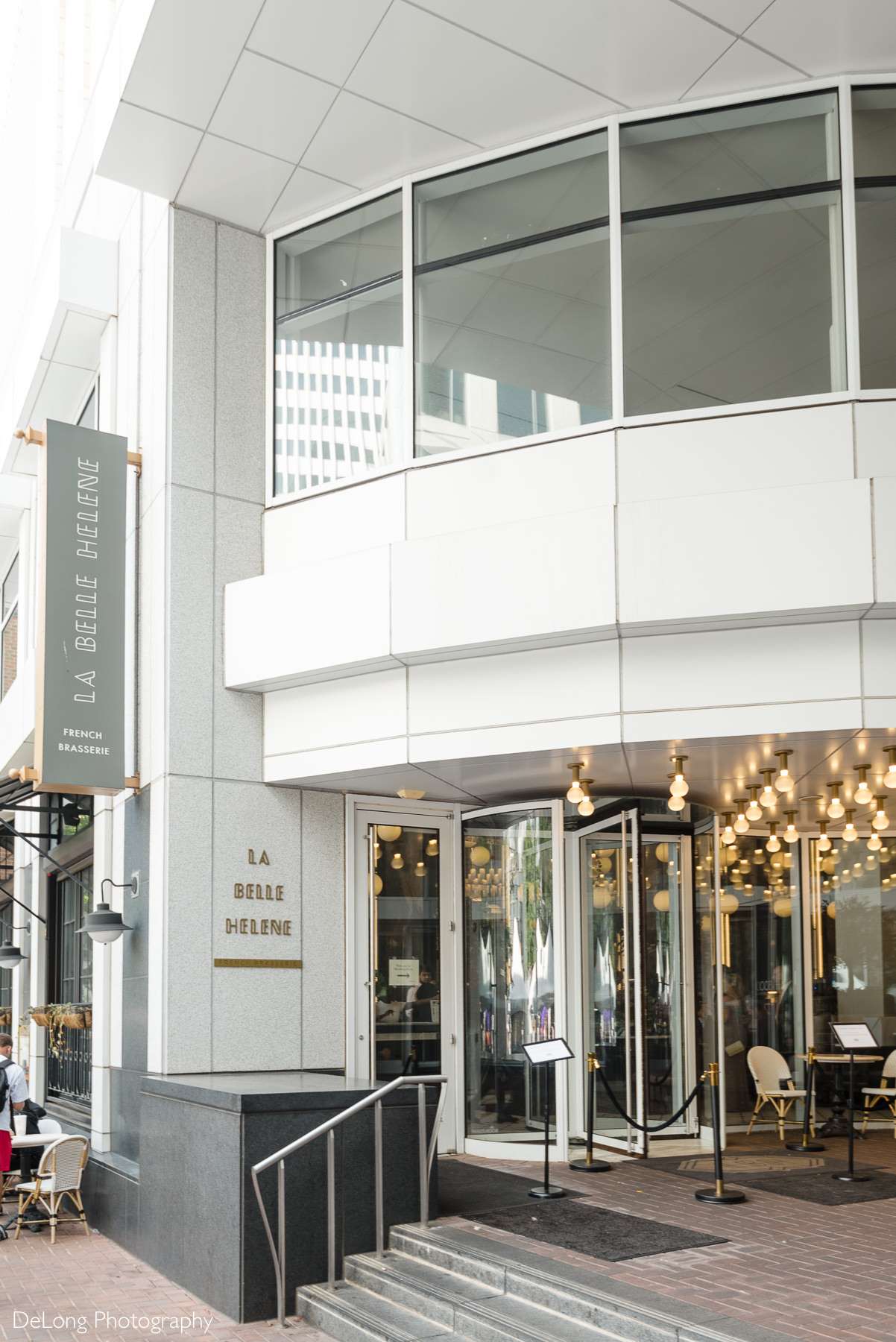Entrance of La Belle Helene in Uptown Charlotte, NC, featuring elegant modern architecture and warm lighting—an inviting French brasserie that serves as a stylish wedding reception venue for intimate celebrations.