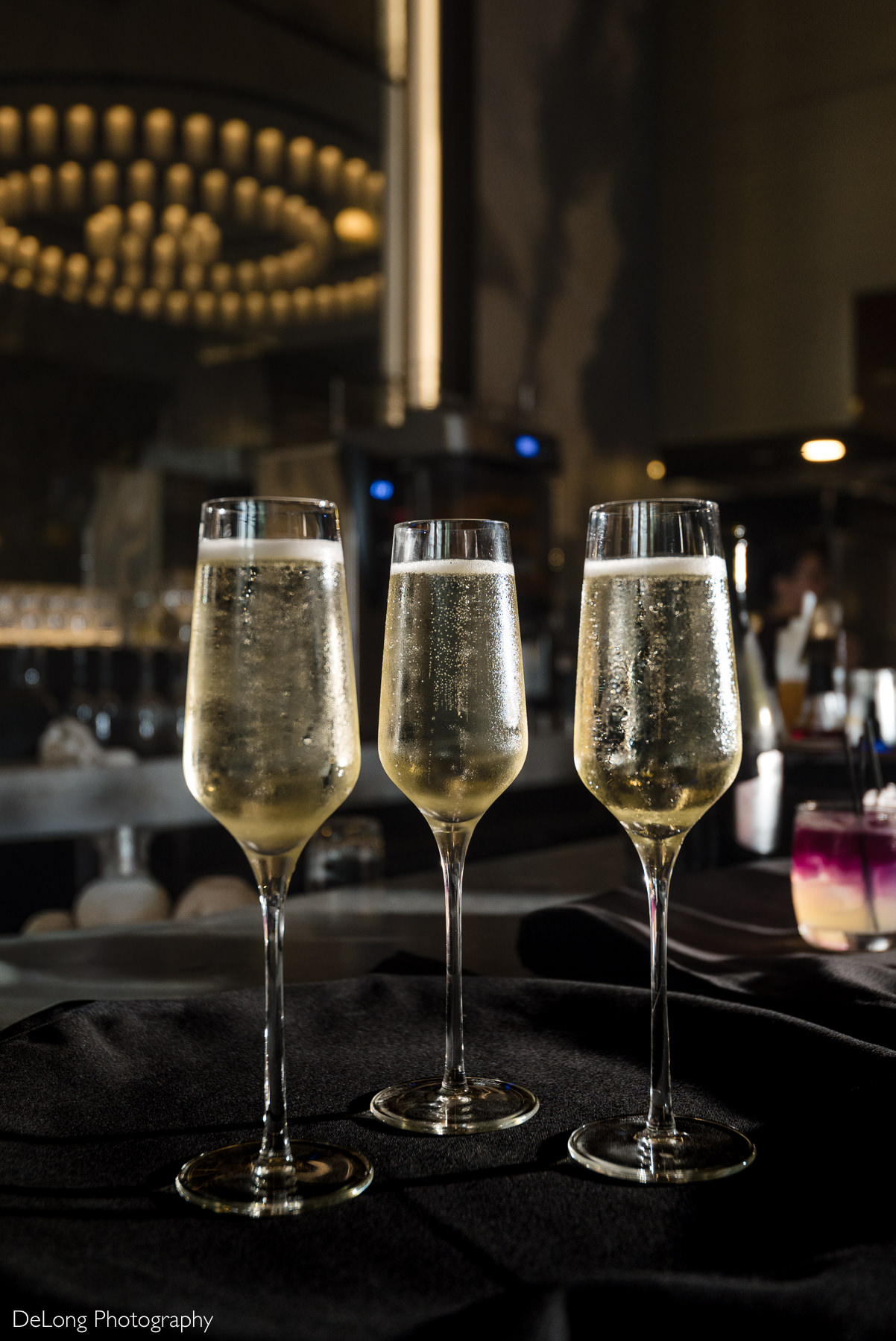 Champagne flutes prepared for a wedding reception at La Belle Helene in Uptown Charlotte, NC, highlighting the elegant bar setting of this French brasserie as a refined restaurant venue for intimate wedding celebrations.