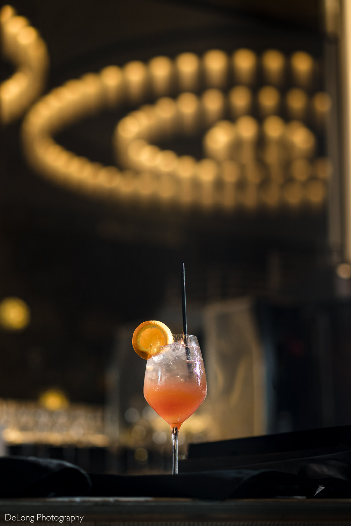 Signature cocktail at La Belle Helene in Charlotte, NC, styled with warm ambient lighting—highlighting the restaurant’s upscale atmosphere for chic wedding receptions and celebration dinners.