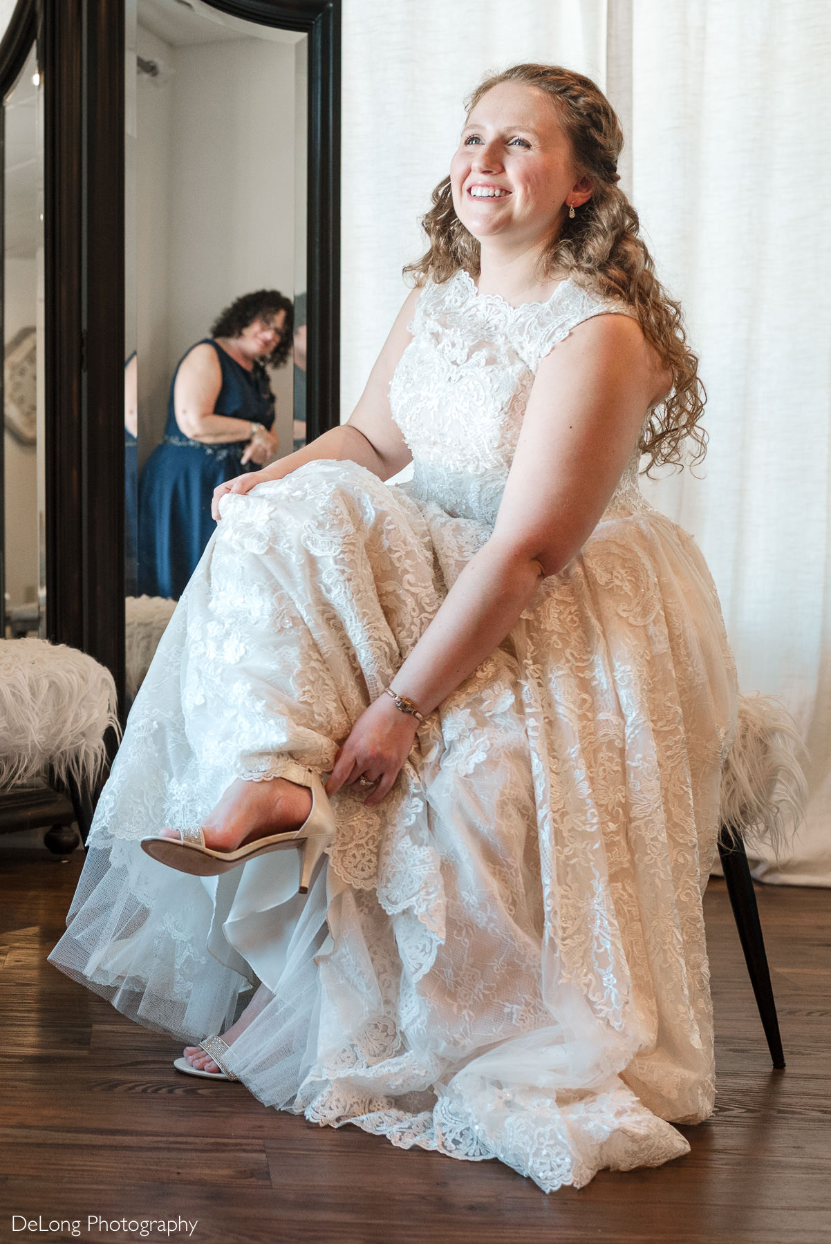 Bride getting ready and putting on her shoes before a winter wedding at Childress Vineyards in Lexington, North Carolina, photographed by DeLong Photography.