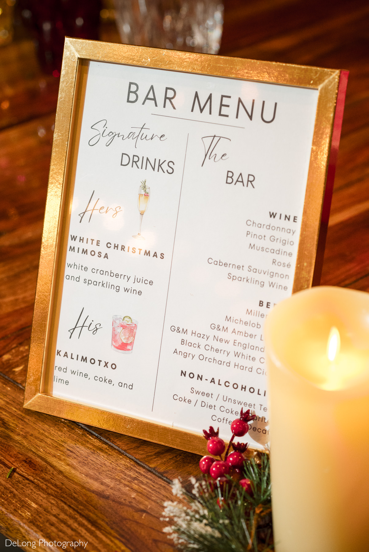 Holiday wedding bar menu displayed in a gold frame at a Childress Vineyards wedding in Lexington, North Carolina, featuring signature cocktails and festive décor.