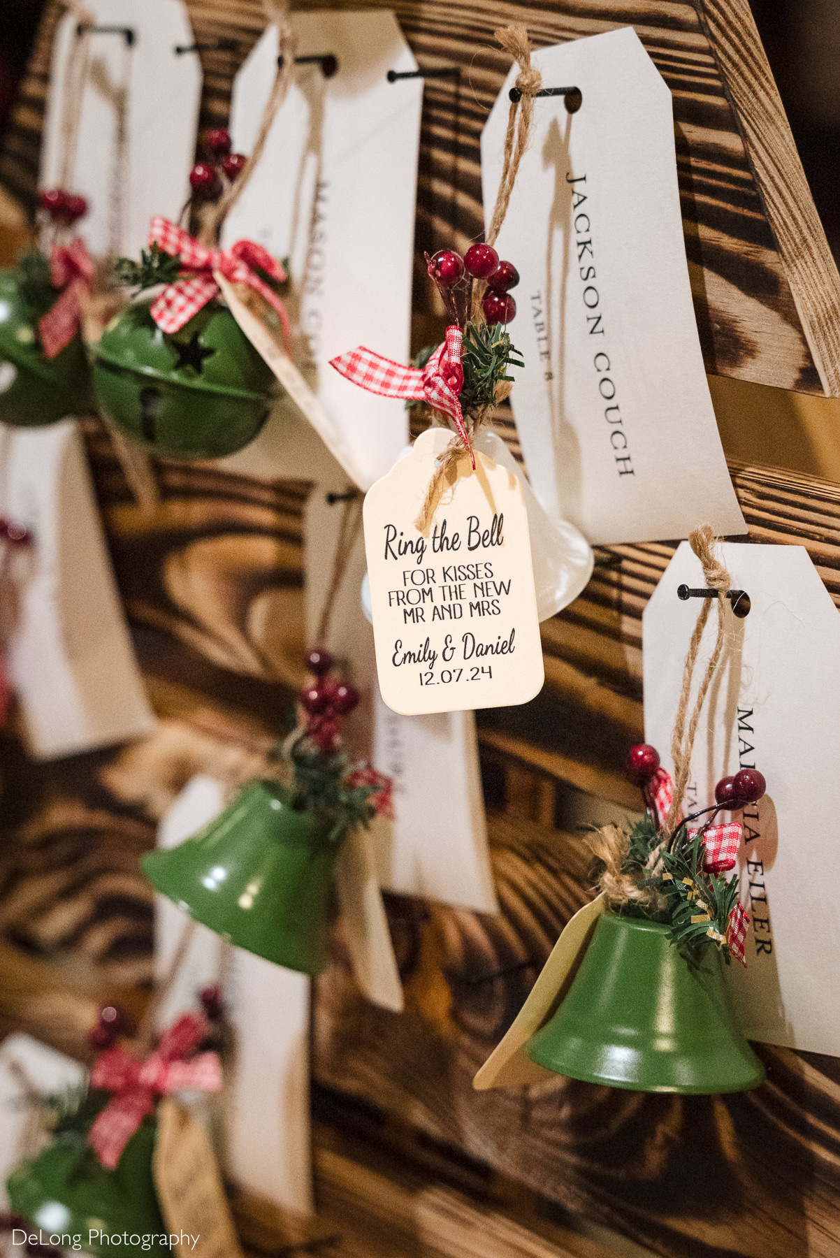 Holiday-inspired wedding escort cards with green bells and personalized tags displayed at a Childress Vineyards wedding in Lexington, North Carolina.