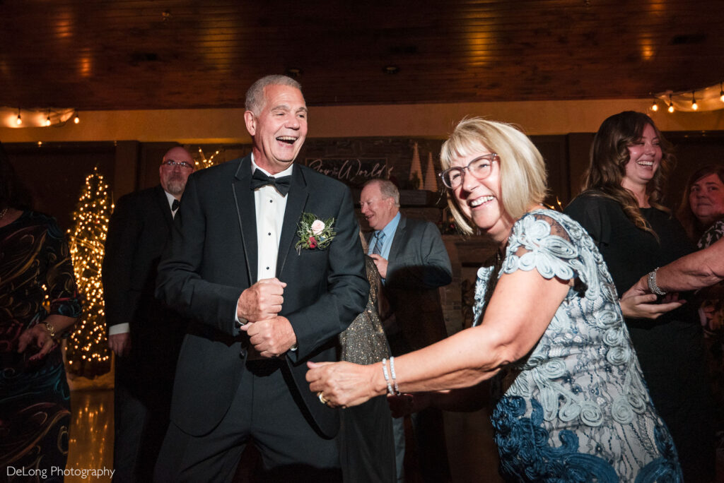 Wedding guests laugh and dance during a joyful reception at Childress Vineyards in Lexington, North Carolina, captured under warm string lights and rustic winery details.