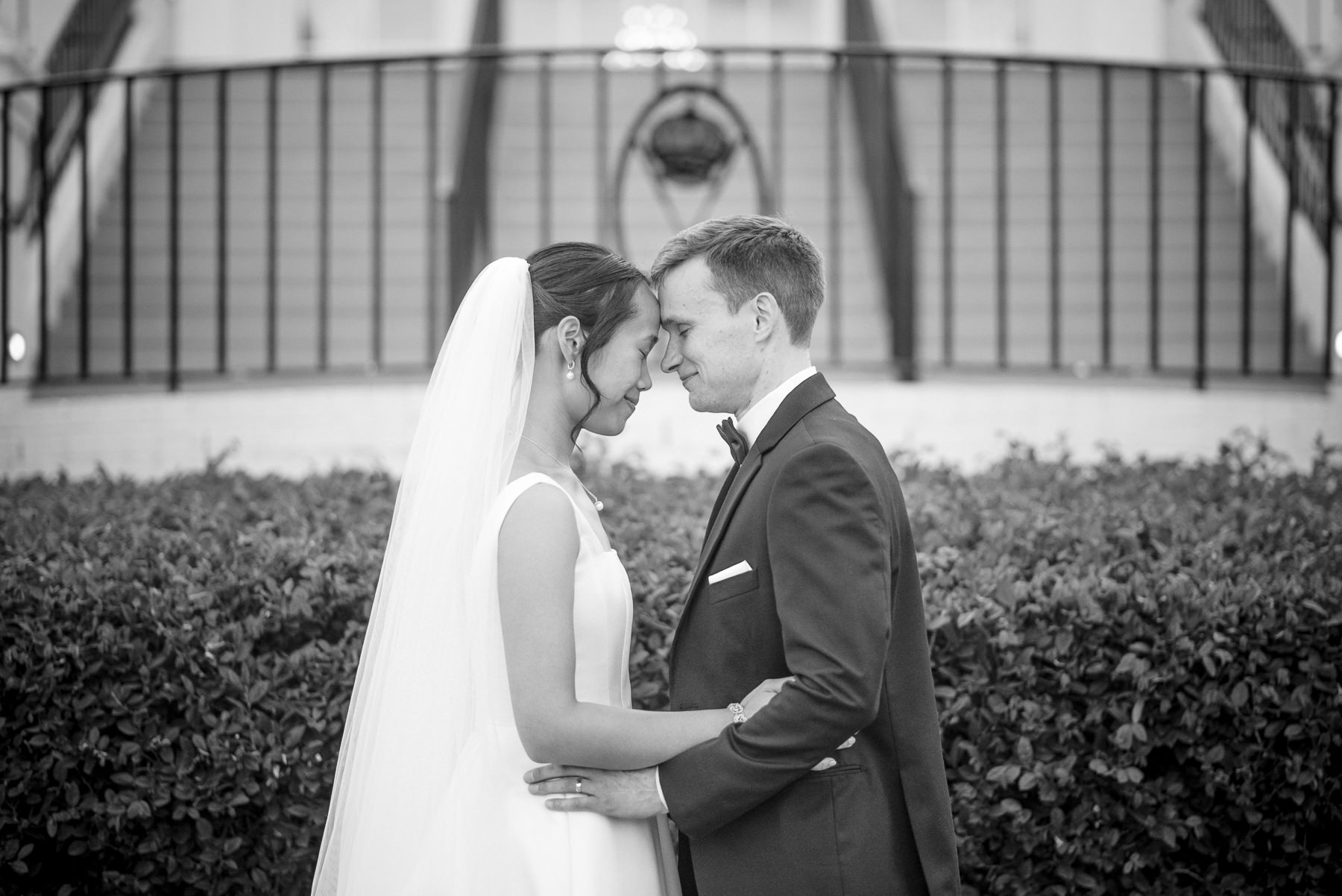 Black and white portrait of a bride and groom sharing an intimate moment during their wedding at Providence Country Club, photographed by DeLong Photography, a Charlotte wedding photographer specializing in timeless wedding photography, candid moments, and elegant country club weddings in Charlotte, NC.