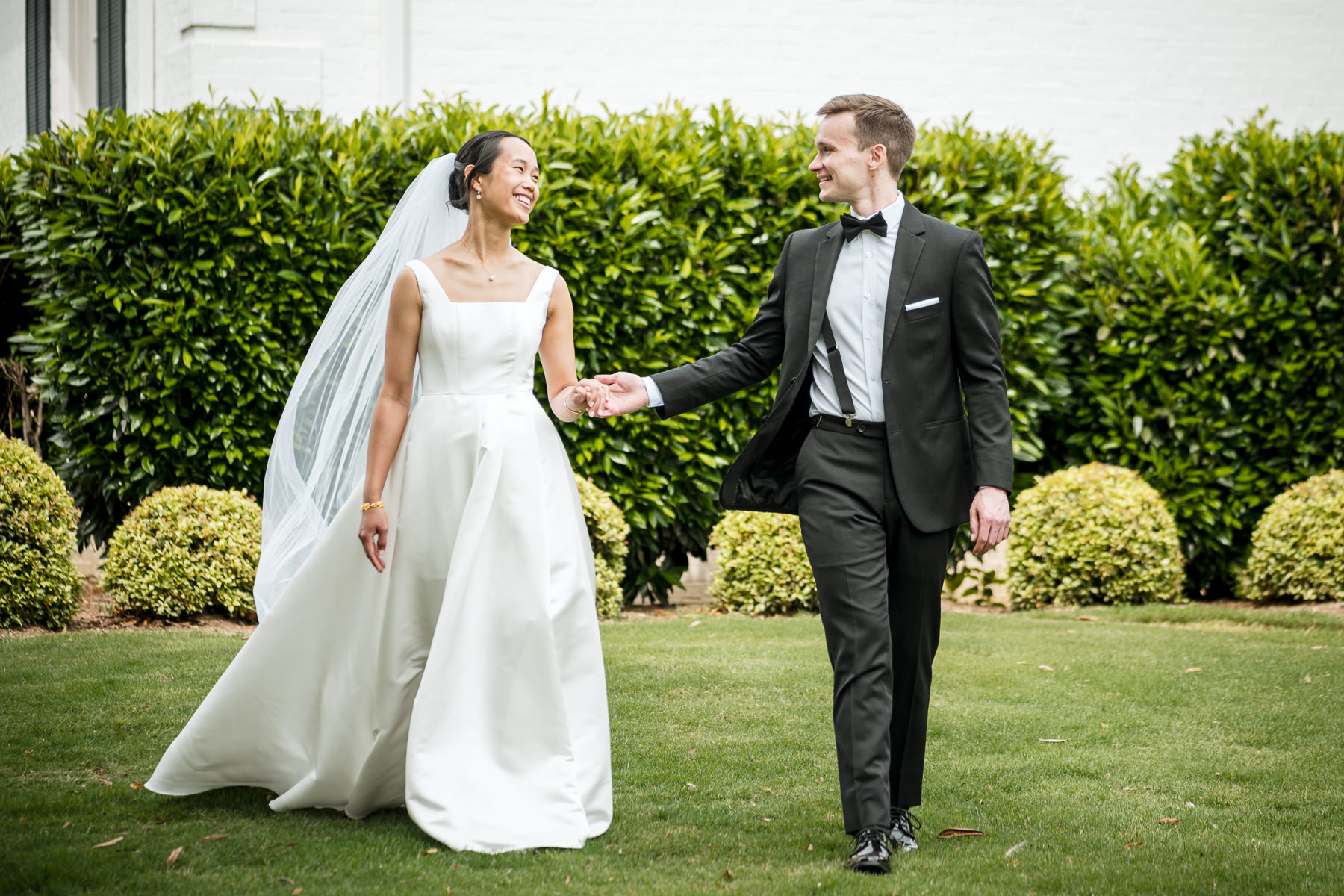 Bride and groom walking hand in hand during wedding portraits at Providence Country Club, photographed by DeLong Photography, a Charlotte wedding photographer known for elegant, candid wedding photography and timeless country club weddings in Charlotte, NC.