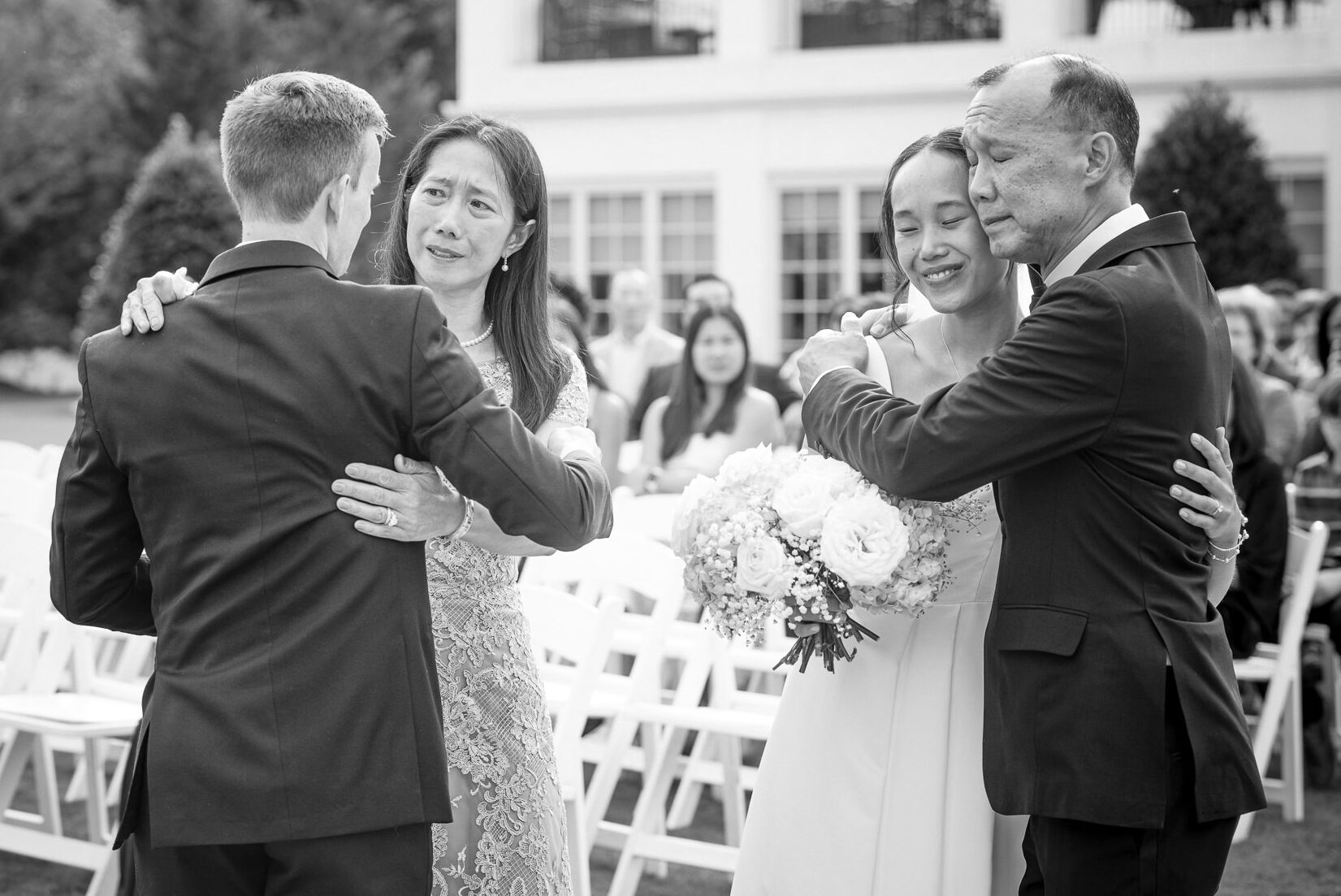 Emotional family embrace during an outdoor wedding ceremony at Providence Country Club, photographed by DeLong Photography, a Charlotte wedding photographer specializing in candid wedding photography and elegant country club weddings in Charlotte, NC.
