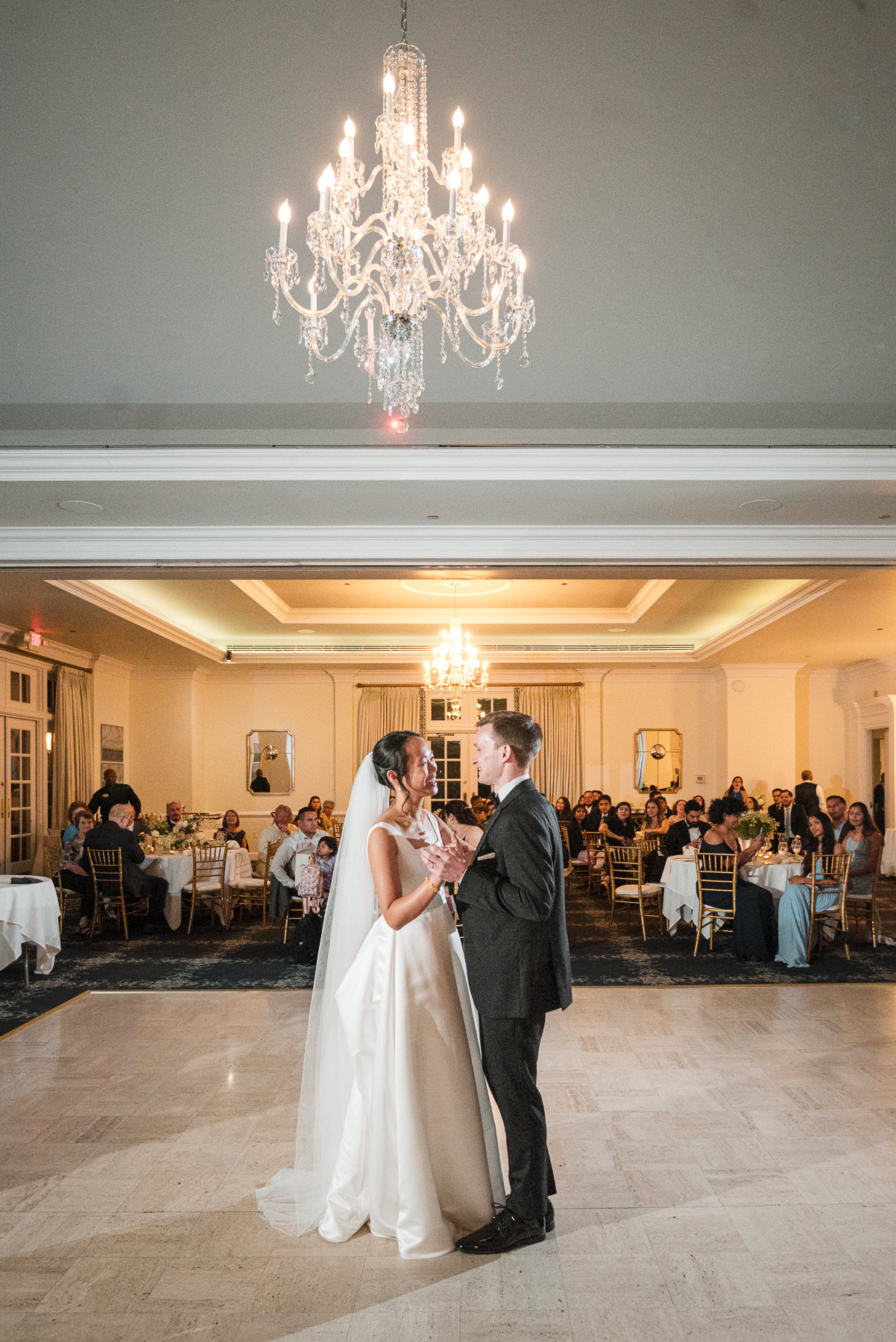 Bride and groom sharing their first dance during their wedding reception at Providence Country Club, photographed by DeLong Photography, a Charlotte wedding photographer specializing in elegant ballroom receptions, candid moments, and timeless wedding photography in Charlotte, NC.