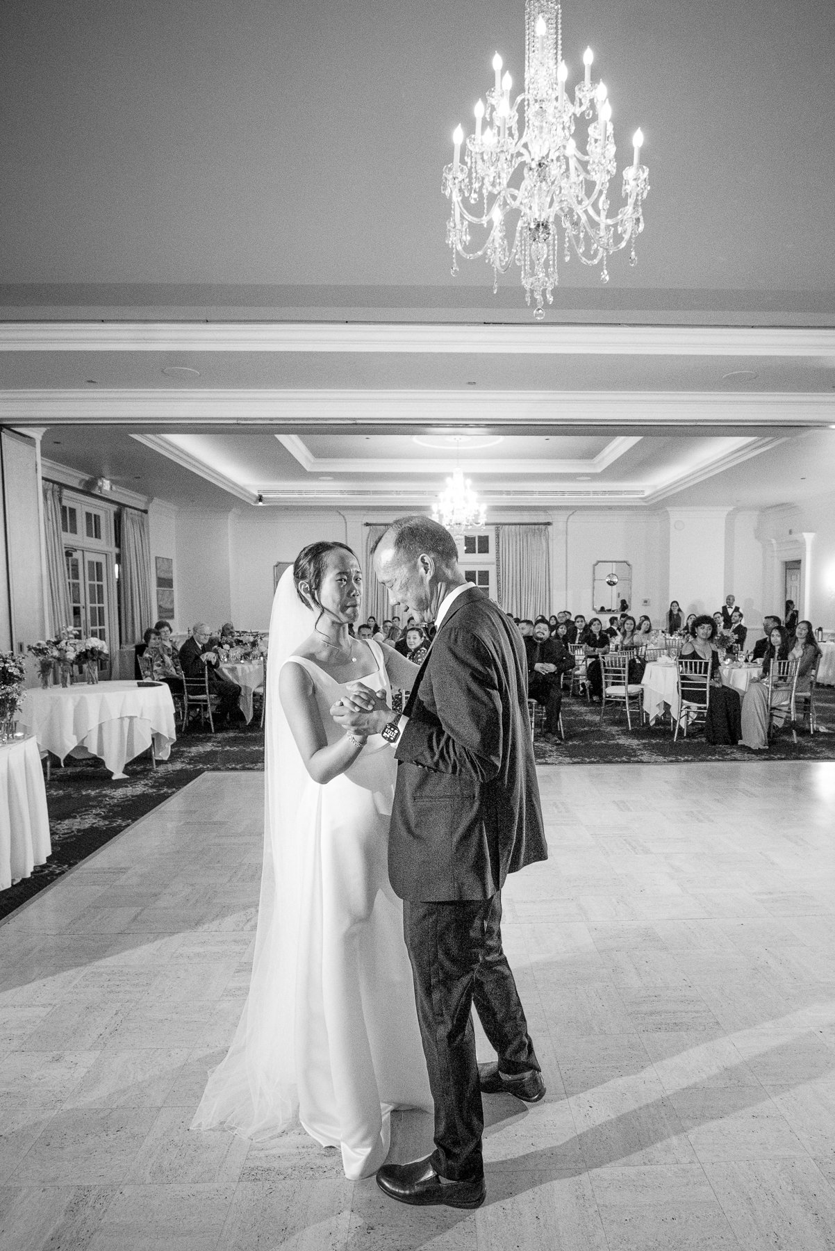 Father-of-the bride and bride share an emotional father-daughter dance during their wedding reception at Providence Country Club, photographed by DeLong Photography, a Charlotte wedding photographer specializing in elegant ballroom receptions, candid moments, and timeless wedding photography in Charlotte, NC.