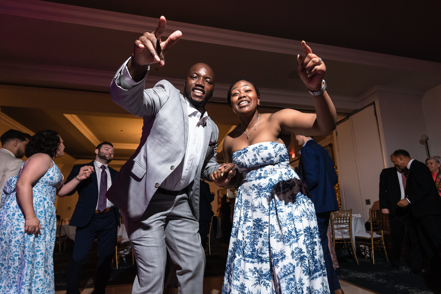 Wedding guests dance and celebrate during a lively reception at Providence Country Club, captured by DeLong Photography in Charlotte, NC. This energetic candid wedding photography showcases the fun, authentic moments couples search for when looking for Charlotte wedding photographers.
