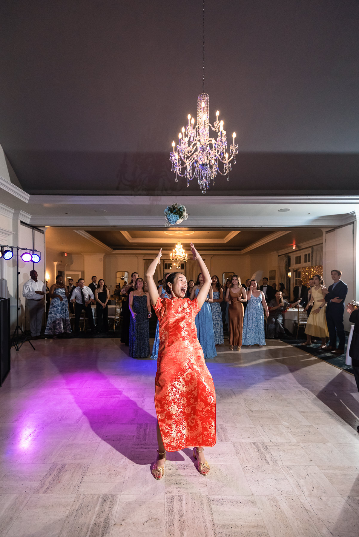 Bouquet toss showing bouquet mis-air during an elegant wedding reception at Providence Country Club, photographed by DeLong Photography, a Charlotte wedding photographer specializing in candid wedding photography, lively reception moments, and timeless country club weddings in Charlotte, NC.