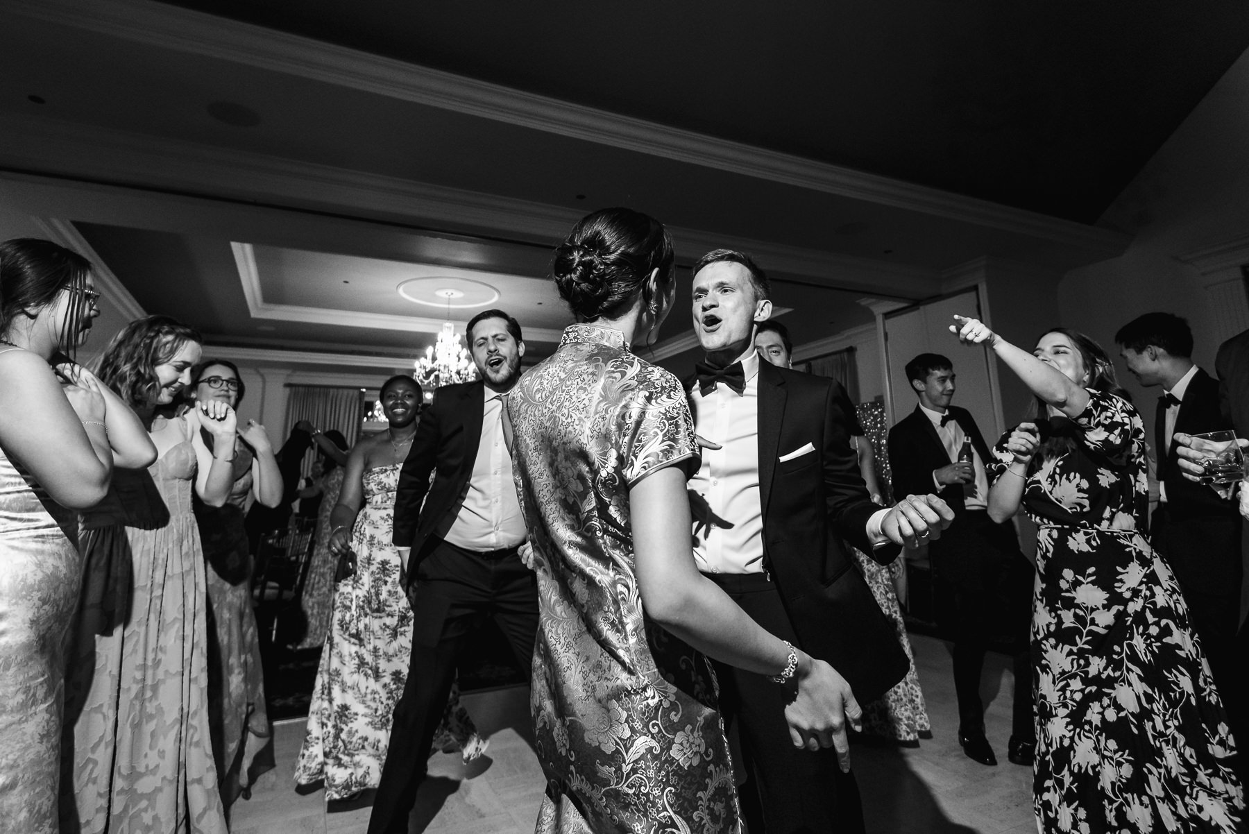 Groom singing to bride on the dance floor during the wedding reception at Providence Country Club, photographed by DeLong Photography, a Charlotte wedding photographer specializing in candid wedding photography, lively reception moments, and timeless country club weddings in Charlotte, NC.