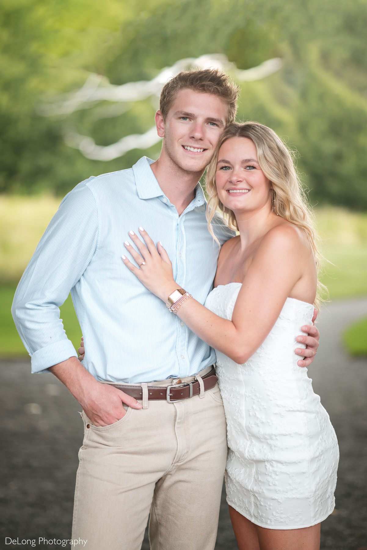 Portrait of an engaged couple during their engagement session in Raleigh, NC, with the couple smiling at the camera. Captured by DeLong Photography, a Raleigh engagement photographer.